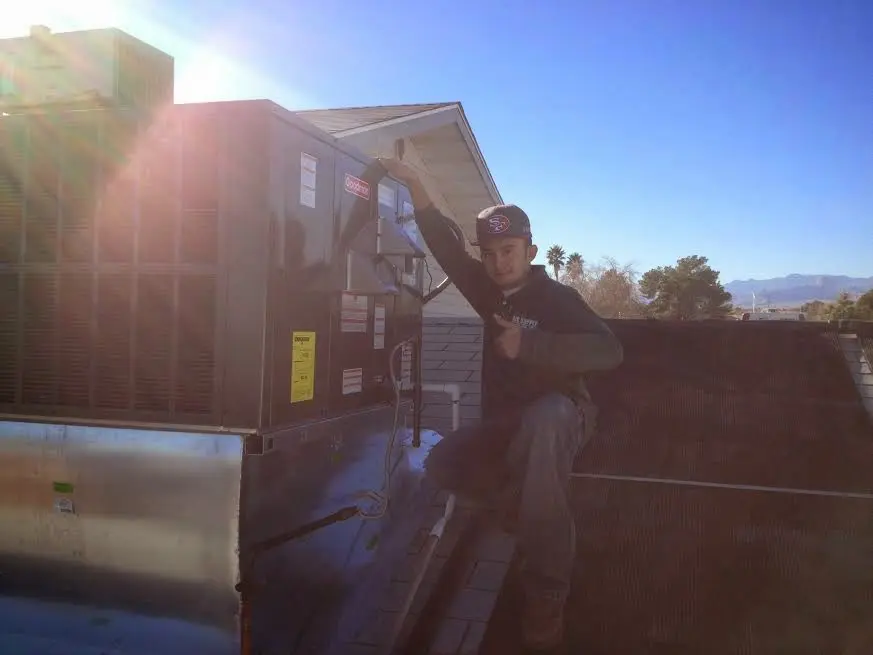 HVAC technician performing Air Duct Cleaning on a rooftop unit in Lodi